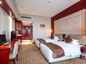 A hotel room with two beds, a desk, a TV, and a bathroom visible through an open door. - Shinewon Continental Hotel (Lu'an)