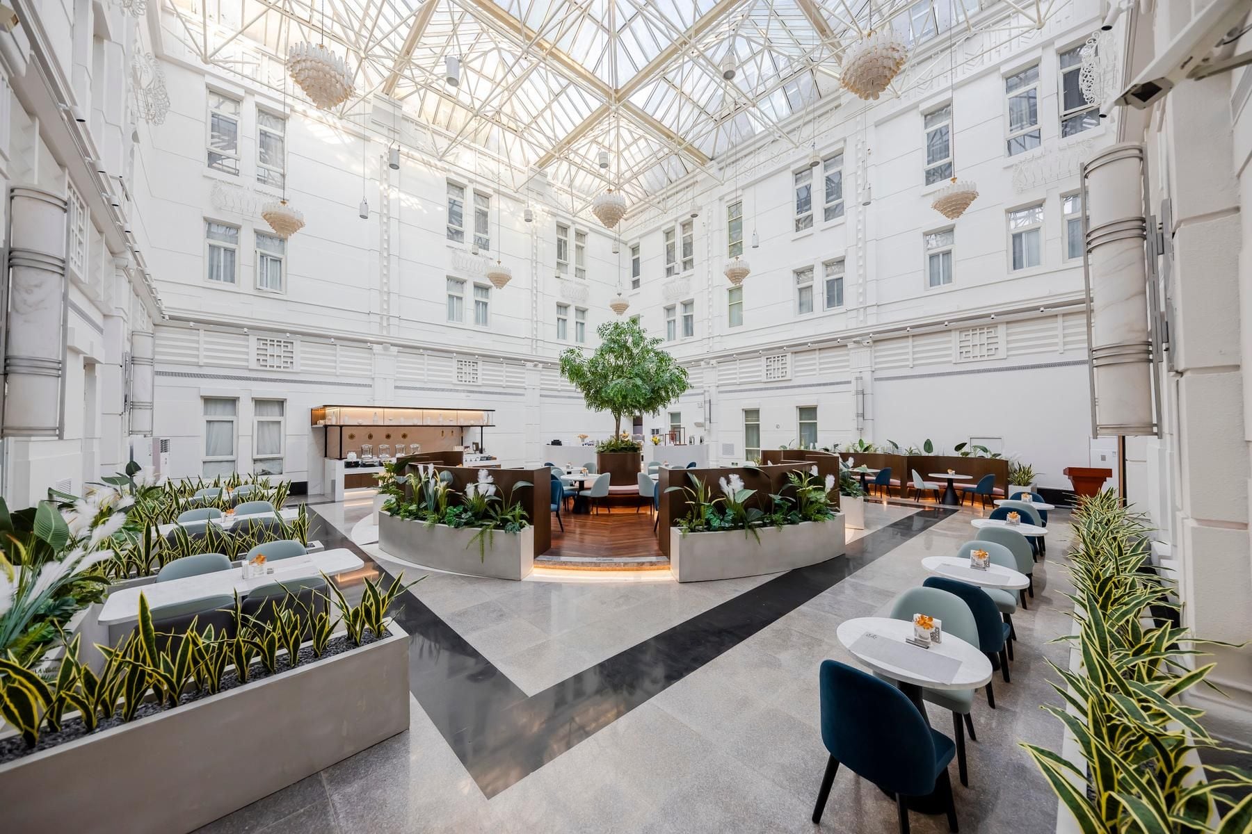 A spacious indoor area with a high ceiling and a central garden.