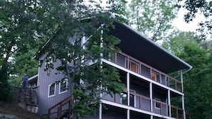 Une maison à deux étages avec un escalier en pierre menant à la porte d’entrée.