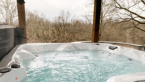 Un bain à remous avec vue sur des arbres sans feuilles en arrière-plan.
