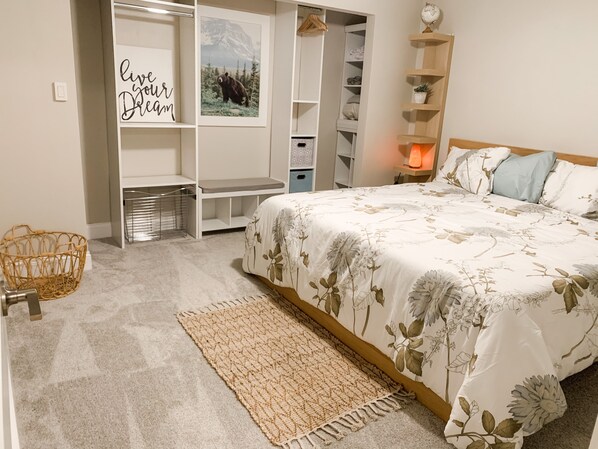 A bedroom with a bed, a woven basket, a wall with a motivational quote, a shelf with decorative items, and a globe. - Underground Earth Home in Hocking Hills, Ohio w/ Hot Tub. Pet-Friendly! (Rockbridge)