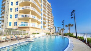 Un hôtel doté d’une piscine, de plusieurs balcons et offrant une vue sur l’océan.