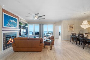 Relax by the fireplace in this spacious living area, featuring a comfortable sofa set and dining space.