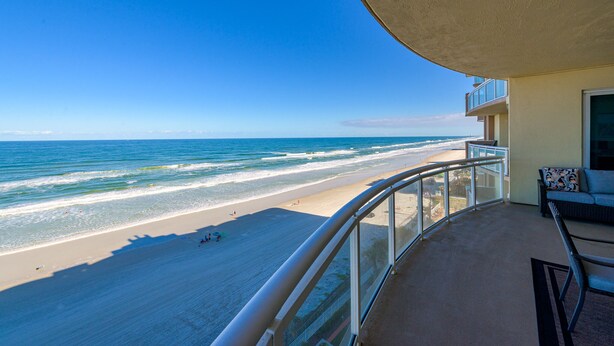 Un balcon avec vue sur une plage et l’océan.