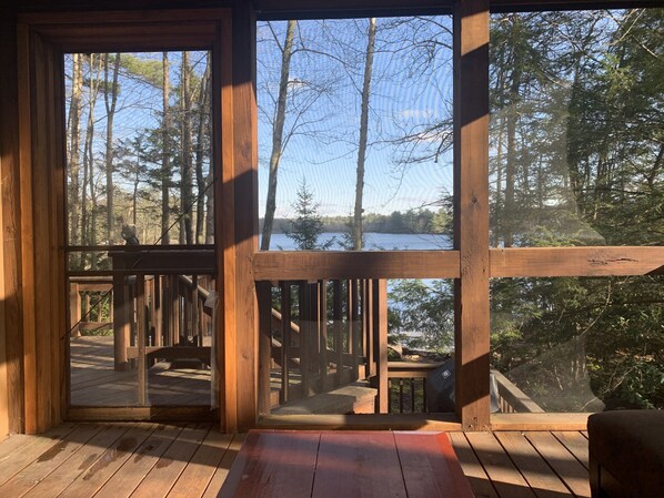 Enjoy a serene view of the surrounding forest and water from the cabin's large windows.