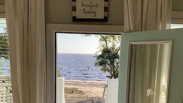 Una puerta que da a una terraza con vista al océano.
