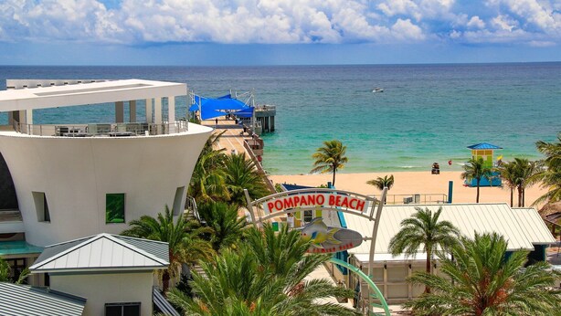 Ranta, josta avautuu näkymä, ja näkymän edessä on kyltti, jossa lukee: ”Pompano Beach”.