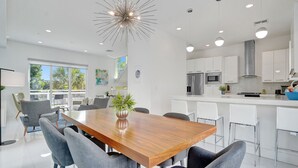A modern kitchen with white cabinets, stainless steel appliances, and a central island. - BEACH ACCESS MODERN TOWNHOUSE! Pool, Spa and Gym! (Pompano Beach)