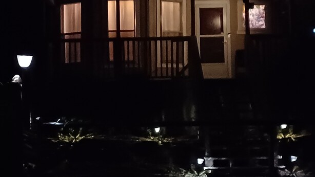 A darkened building with illuminated windows and a visible door. - Convenient Family-Friendly Home -10 Min to Tulsa!" (Tulsa)