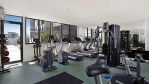 Een moderne sportschool met loopbanden, elliptische trainers en gewichten.