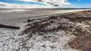 Ein Strand mit klarem Himmel und vereinzelten Wolken.