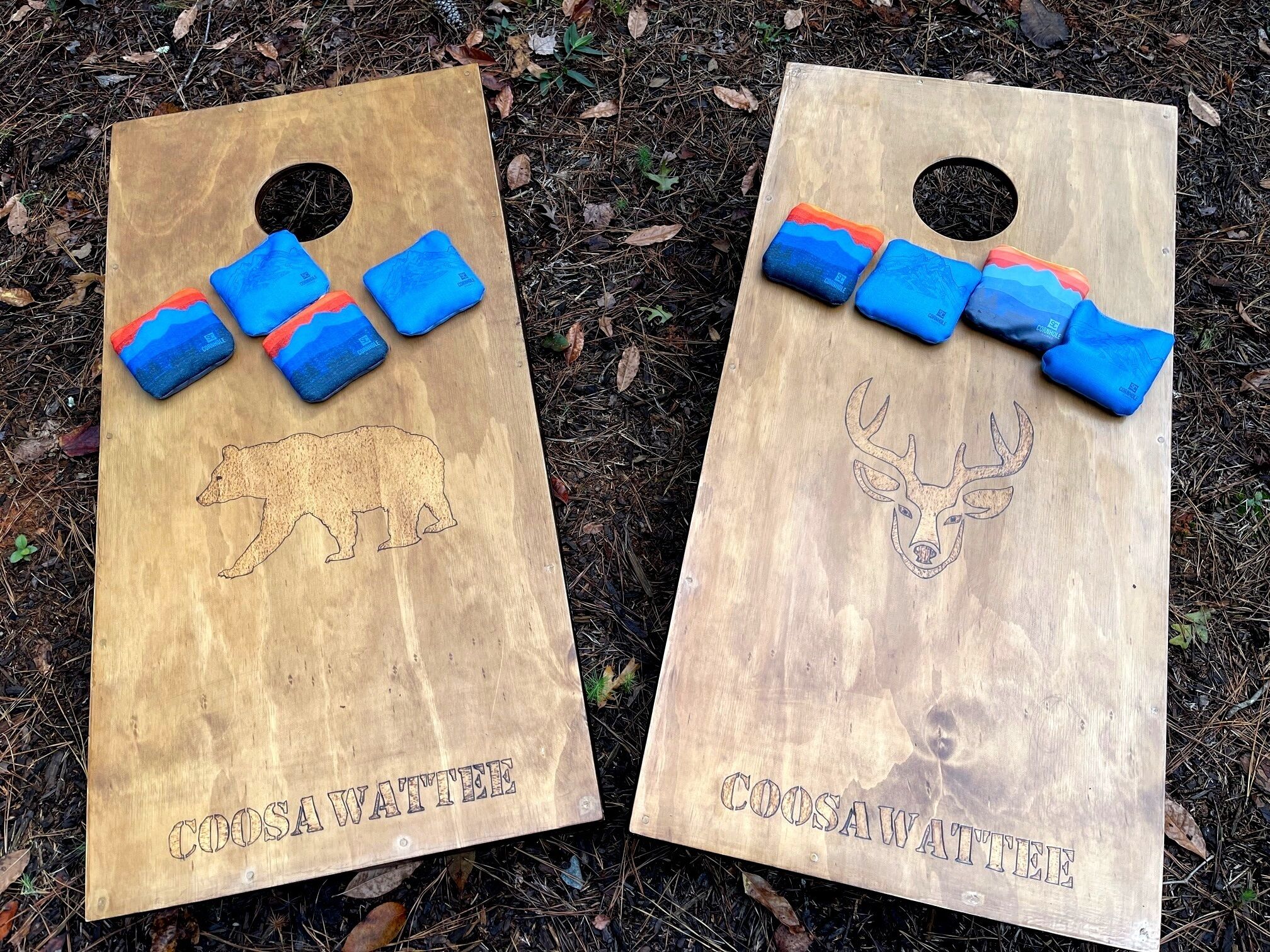 Two wooden boards with animal engravings and the text "COOSA WATTEE" on them.