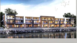 A modern hotel with multiple balconies, a waterfront view, and a stone facade. - Mariners Cove Mindarie ~ Luxe Marina Waterfront (Mindarie)