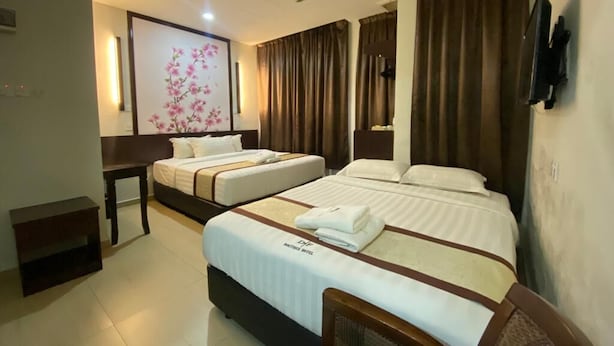 A hotel room with two beds, a desk, and a large floral artwork on the wall. - D&f BOUTIQUE HOTEL SENAWANG (Seremban)