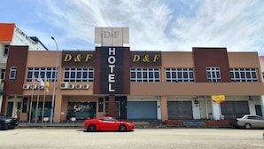 A D&F Hotel with a modern facade, large windows, and a red sports car parked in front. - D&f BOUTIQUE HOTEL SENAWANG (Seremban)
