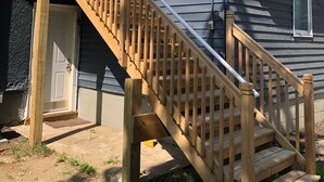 Une maison à deux étages avec un escalier en bois et un balcon.