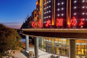 Un hôtel doté d’une enseigne lumineuse bien visible, de grandes fenêtres et d’une architecture moderne.