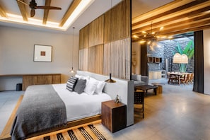 Un dormitorio moderno con una cama grande, una mesita de noche y vistas a un comedor.