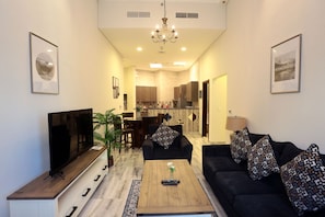 Relax in this stylish living room with a flat-screen TV, comfortable sofa, and a potted plant.