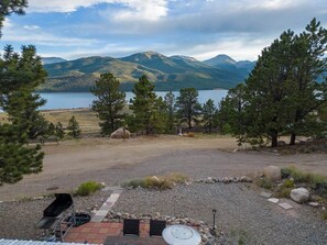 A campsite with a barbecue grill, picnic table, and a scenic view of mountains and a lake. - Mountain Cabin with Lake Access and BBQ (Twin Lakes)