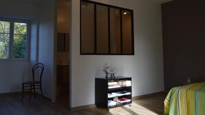 A room with a large window, a bookshelf, and a bed with a striped bedspread. - **Spacious Gîte Near Argenton-sur-Creuse: 2 Houses, Garden, Parking, Family-Friendly** (Argenton-sur-Creuse)