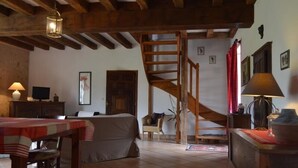 A cozy room with a bed, a desk, a chair, a lamp, and a staircase. - **Spacious Gîte Near Argenton-sur-Creuse: 2 Houses, Garden, Parking, Family-Friendly** (Argenton-sur-Creuse)
