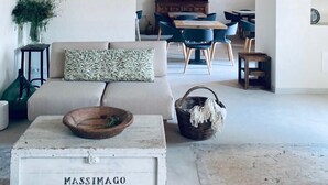 A rustic interior with exposed wooden beams, a dining area with blue chairs, and a white sofa with patterned cushions. - Corte Massimago (Mezzane di Sotto)