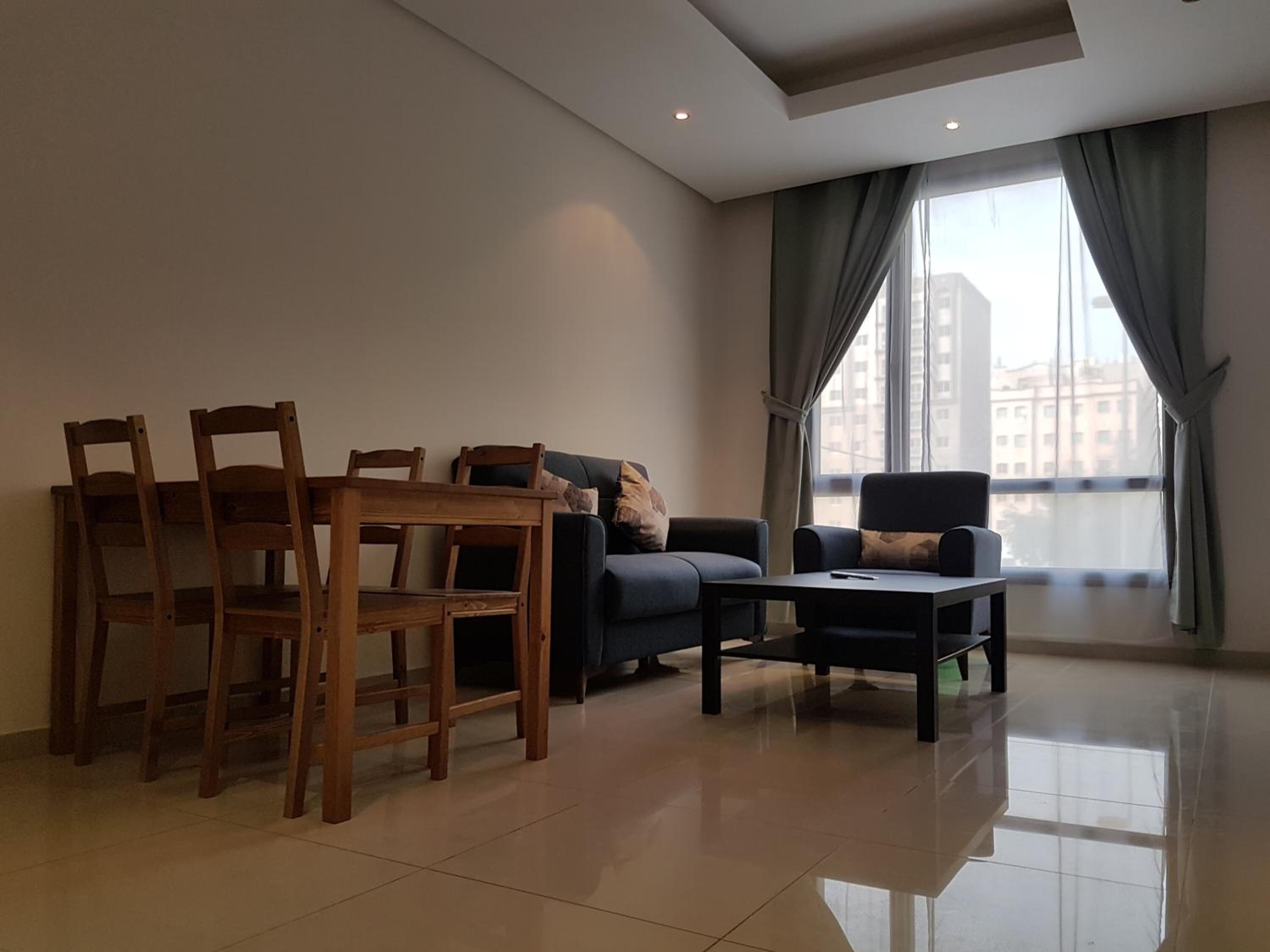 A modern living room with a dining table, chairs, a sofa, and a coffee table.