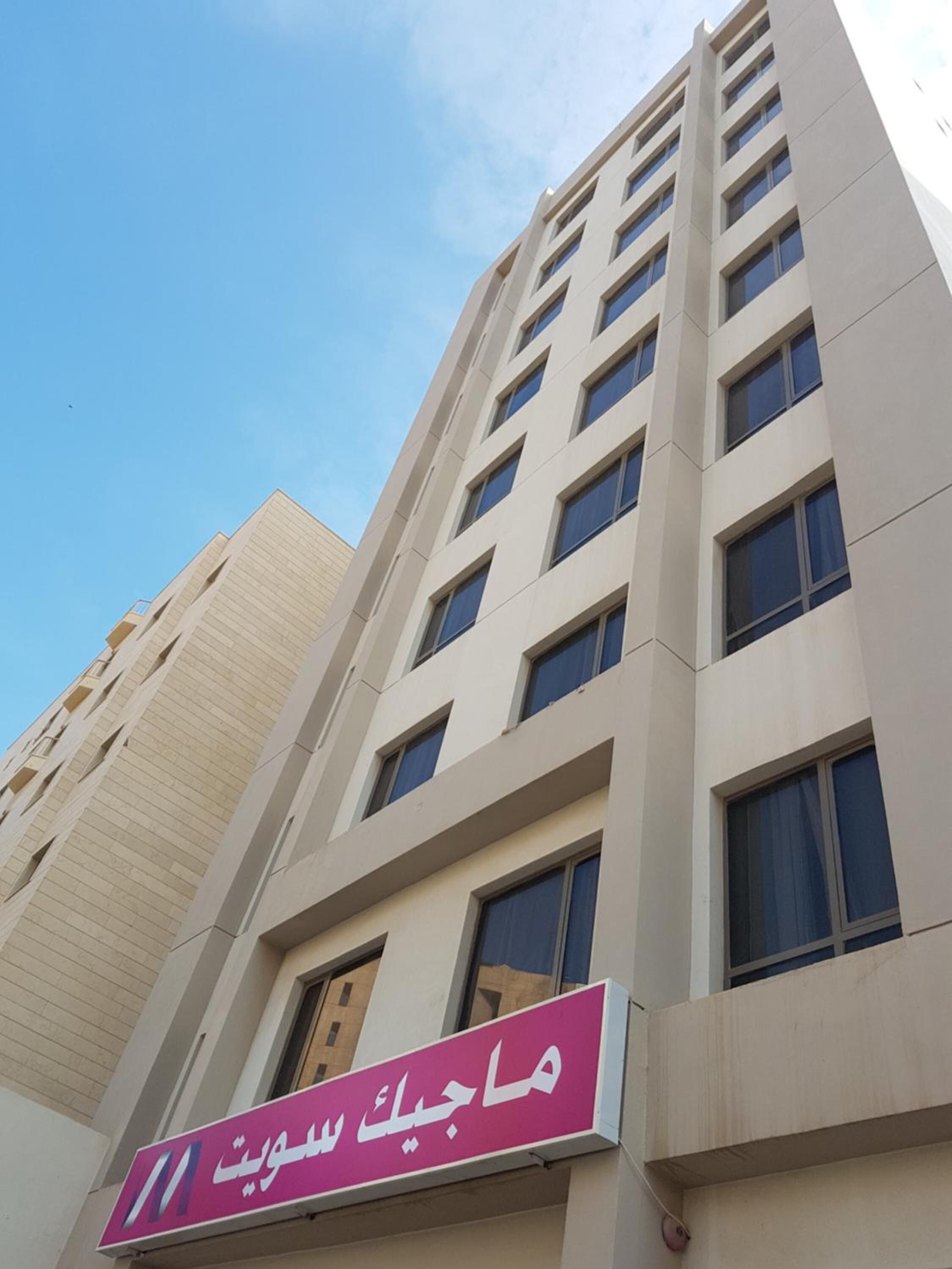A tall building with a sign in Arabic.