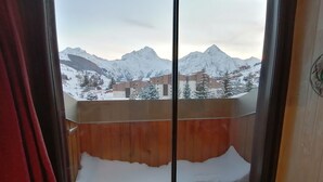 A room with a large window overlooking a snowy mountain landscape. - South expo studio, heart resort, calm, ski to door (Les Deux Alpes)