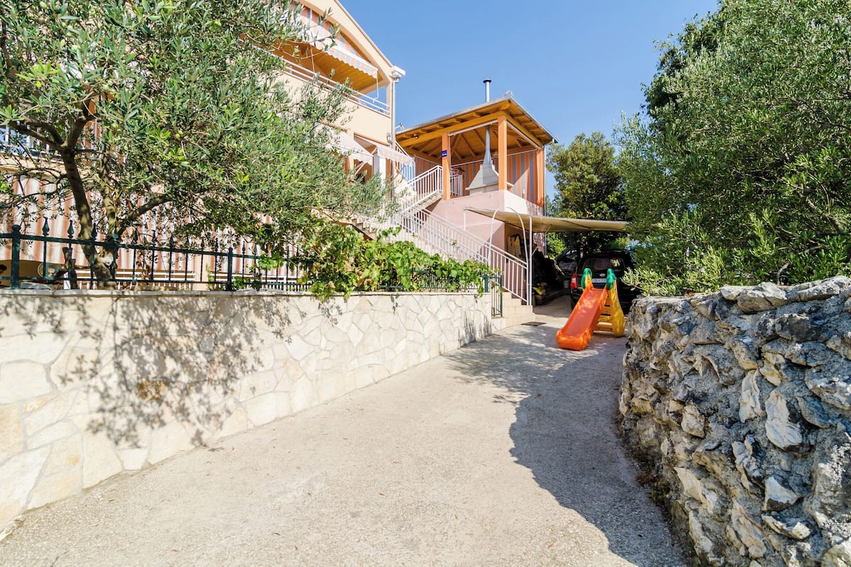A pathway leading to a building with a wooden structure and a slide.