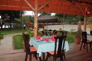 Dine al fresco amidst lush surroundings and a serene water view.