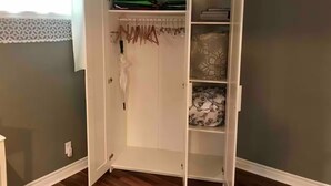 Un dressing avec les portes ouvertes, laissant apparaître des étagères et un espace pour suspendre les vêtements.