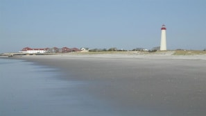 A beach with a lighthouse and several buildings in the background. - Beautiful 6 BR House in center of Historic District 1 Block to Beach (Cape May)