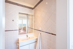Ein Badezimmer mit Waschbecken, Spiegel und Handtuchhalter.