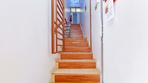 Una escalera que lleva a una habitación con una cama, una ventana y una puerta.