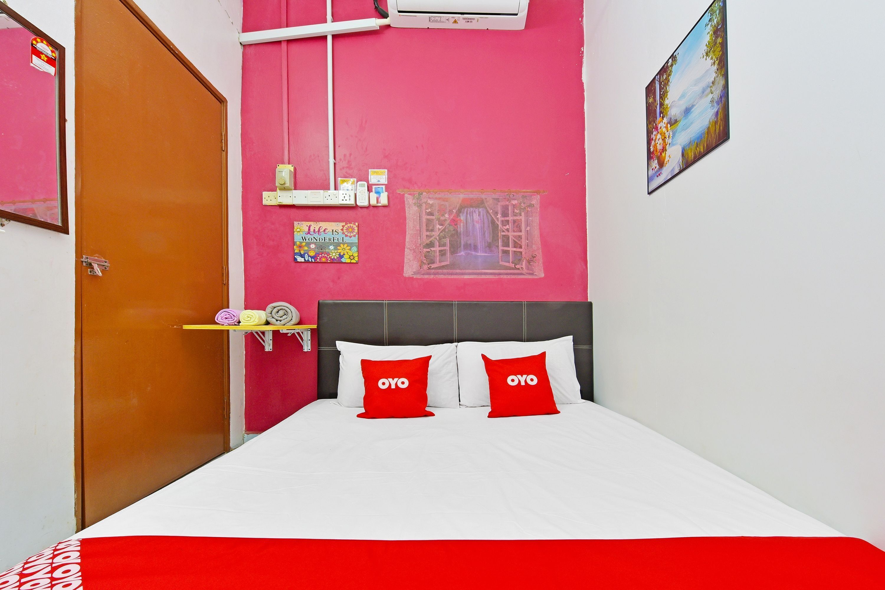 Una habitación con cama, ventana con vistas, aire acondicionado de pared y puerta.