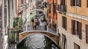 Un canal estrecho bordeado por edificios históricos con balcones y un puente.