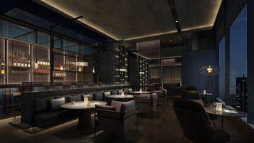 A modern bar area with seating and a city view.