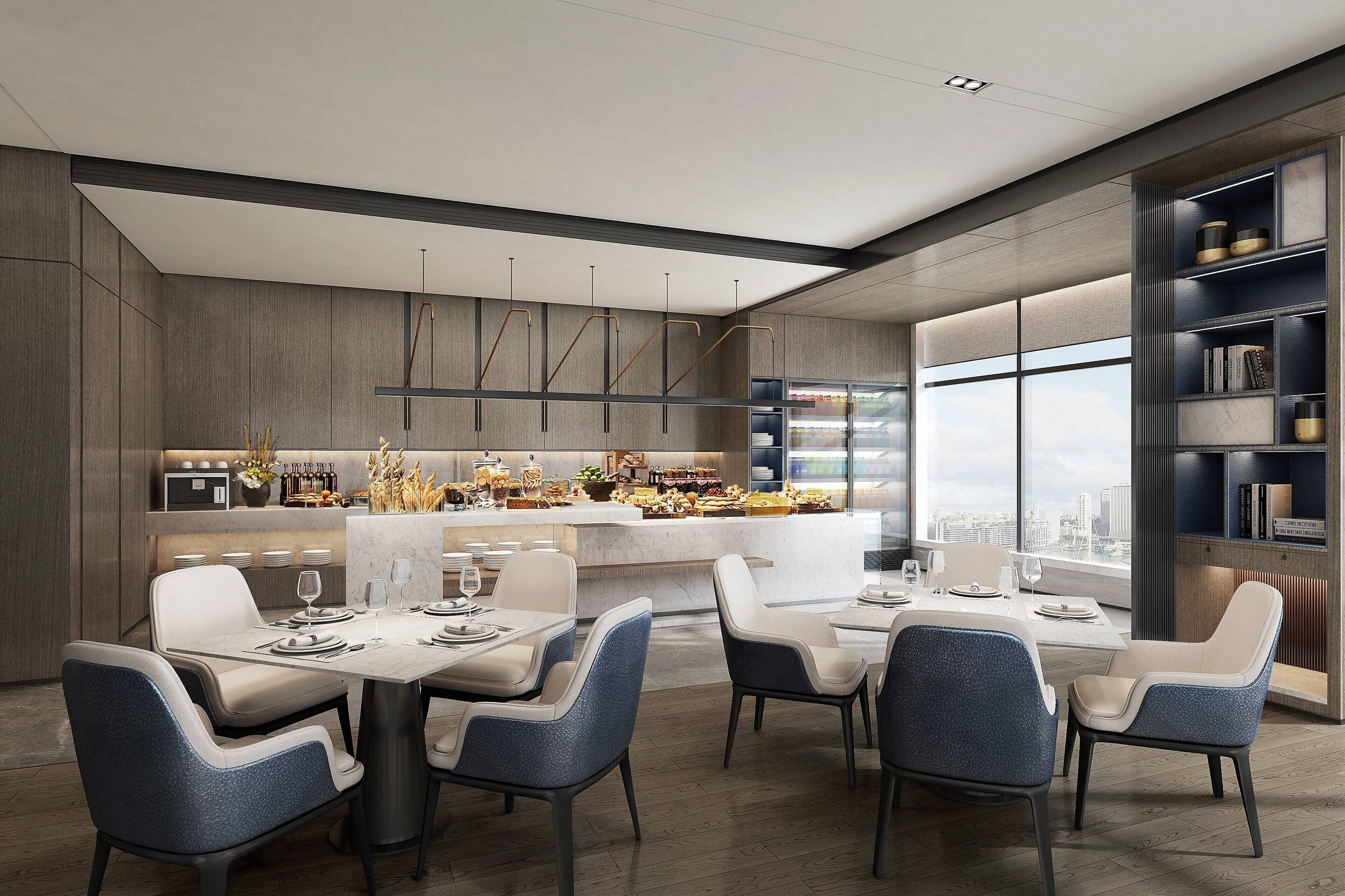 A modern dining area with a central island, seating, and a view of the city.