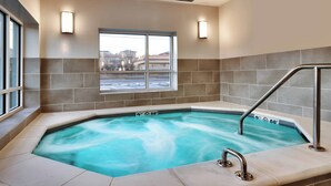 A hot tub with a view of a building outside, a window, and a metal railing. - TownePlace Suites by Marriott Salt Lake City Murray (Murray)