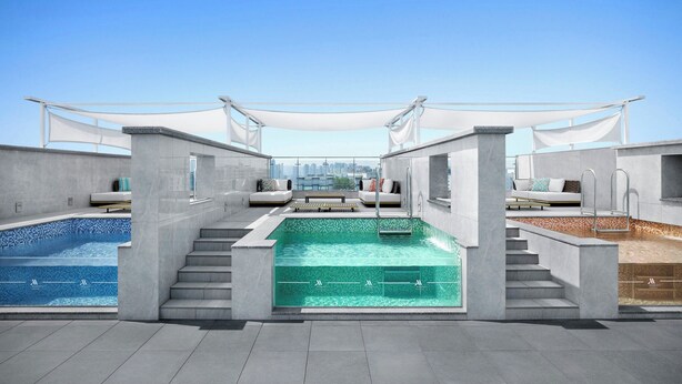 Ein Dachpool mit Blick auf die Stadt, umgeben von moderner Architektur und Außenbereichen zum Verweilen.