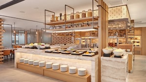 Ein modernes Buffet mit mehreren Servierstationen, einer vielfältigen Auswahl an Speisen und einem klaren, zeitgemäßen Design.