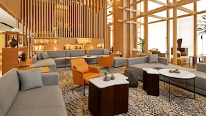 Eine moderne Hotelhalle mit großzügiger Sitzecke, Holzvertäfelung und großen Fenstern.