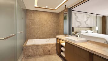 A modern bathroom with a bathtub, vanity, and a large mirror.