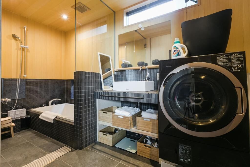 Ein modernes Badezimmer mit einer Badewanne, einer Dusche und einer Waschmaschine.