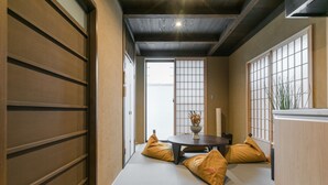 A traditional Japanese room with tatami flooring, a low table with cushions, and sliding doors. - No.8 Kyoto (Kyoto)
