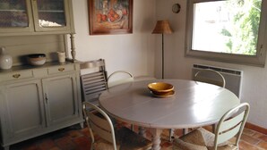A dining area with a round table, chairs, a bowl, a lamp, and a painting on the wall. - Town center with terrace (Aix-en-Provence)