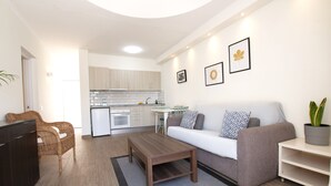 A modern living room with a sofa, coffee table, and a dining area with a table and chairs. - VM7, first floor. (El Cotillo)