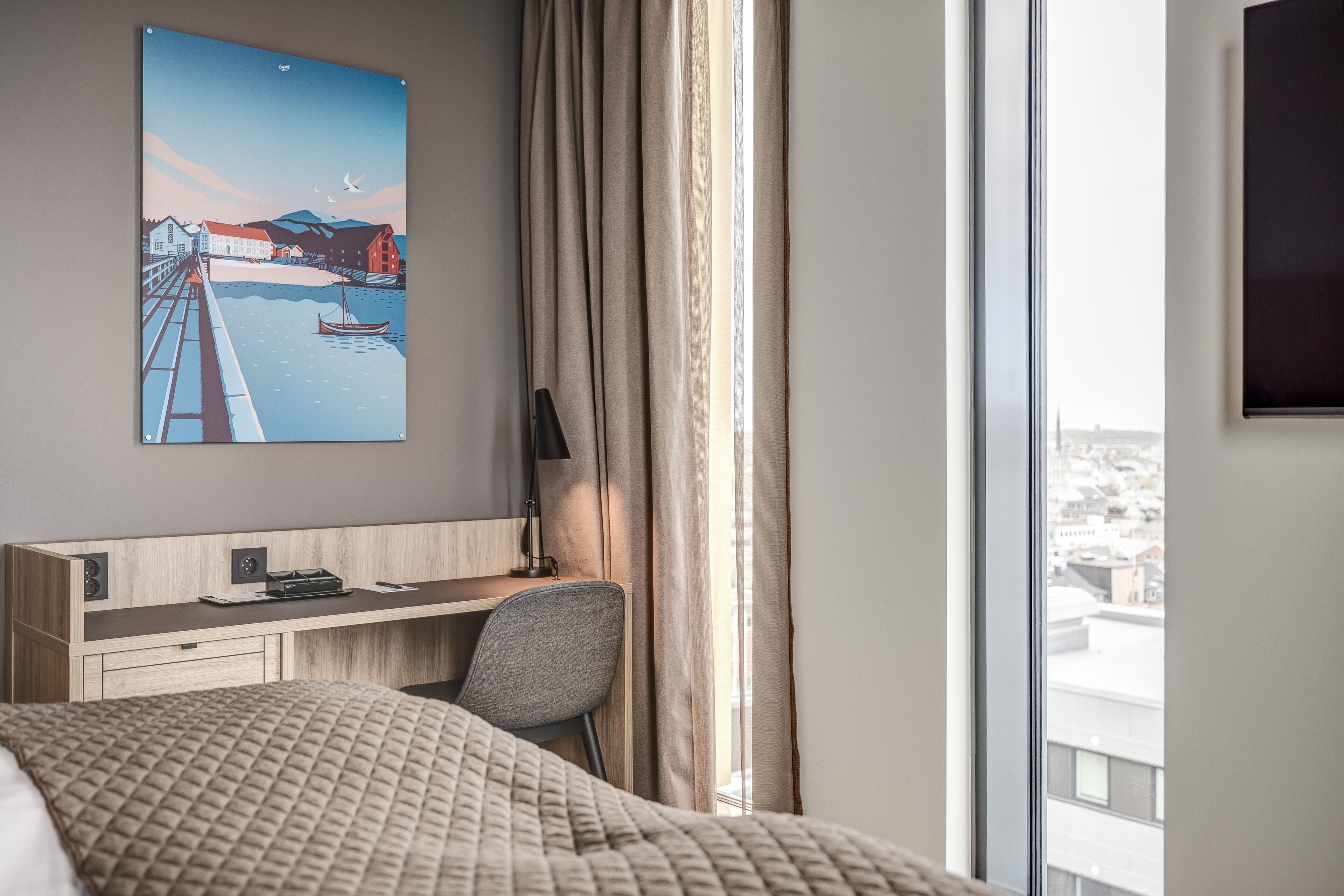 A hotel room with a bed, a desk, a chair, a window with curtains, and a city view.